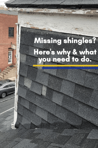 Close-up of a house roof with several missing shingles. White trim and brick building visible.