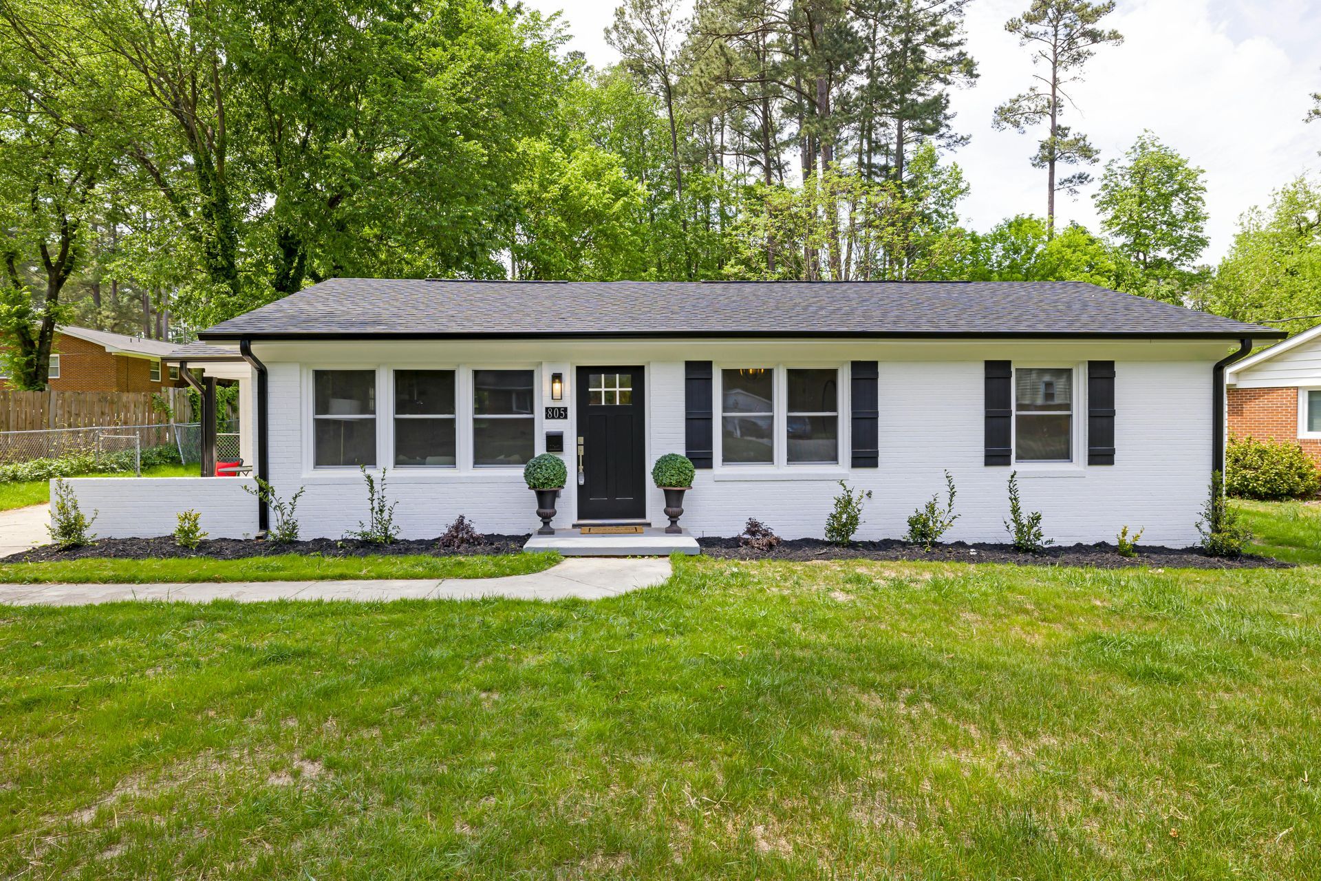 Two-story blue house with shutters, attached two-car garage, green lawn, and a mailbox.