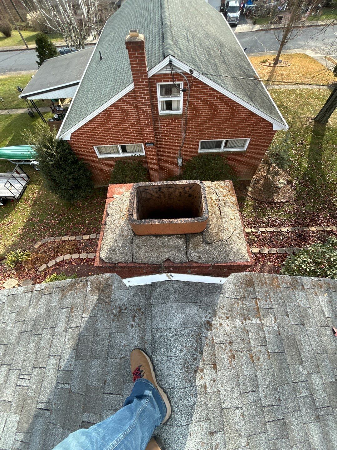 Roof inspection around a brick chimney on Reber Street in Shoemakersville, PA showing flashing and asphalt shingles.