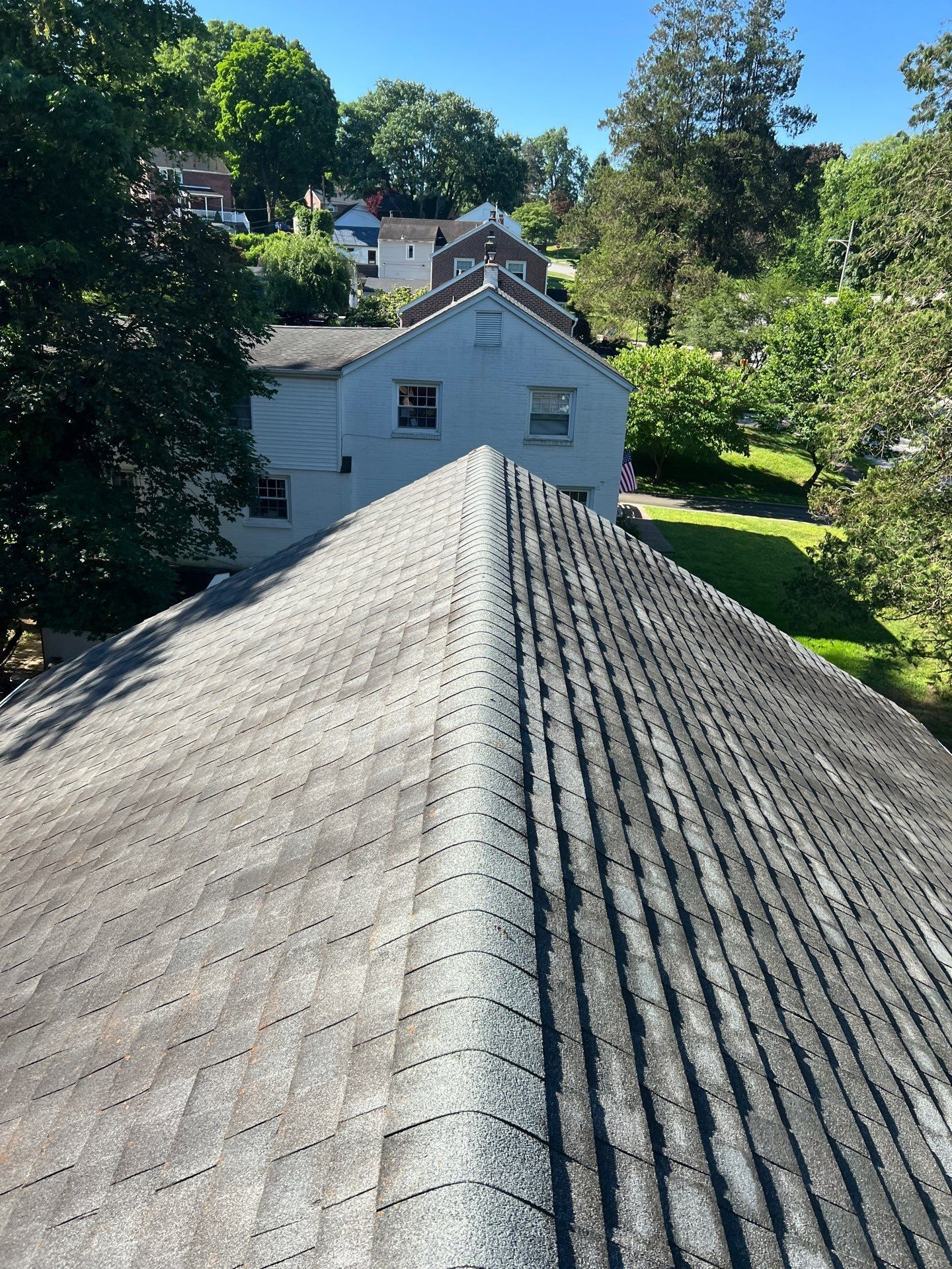 Asphalt shingle roof with ridge cap viewed from above on Ashwood Road in Springfield PA