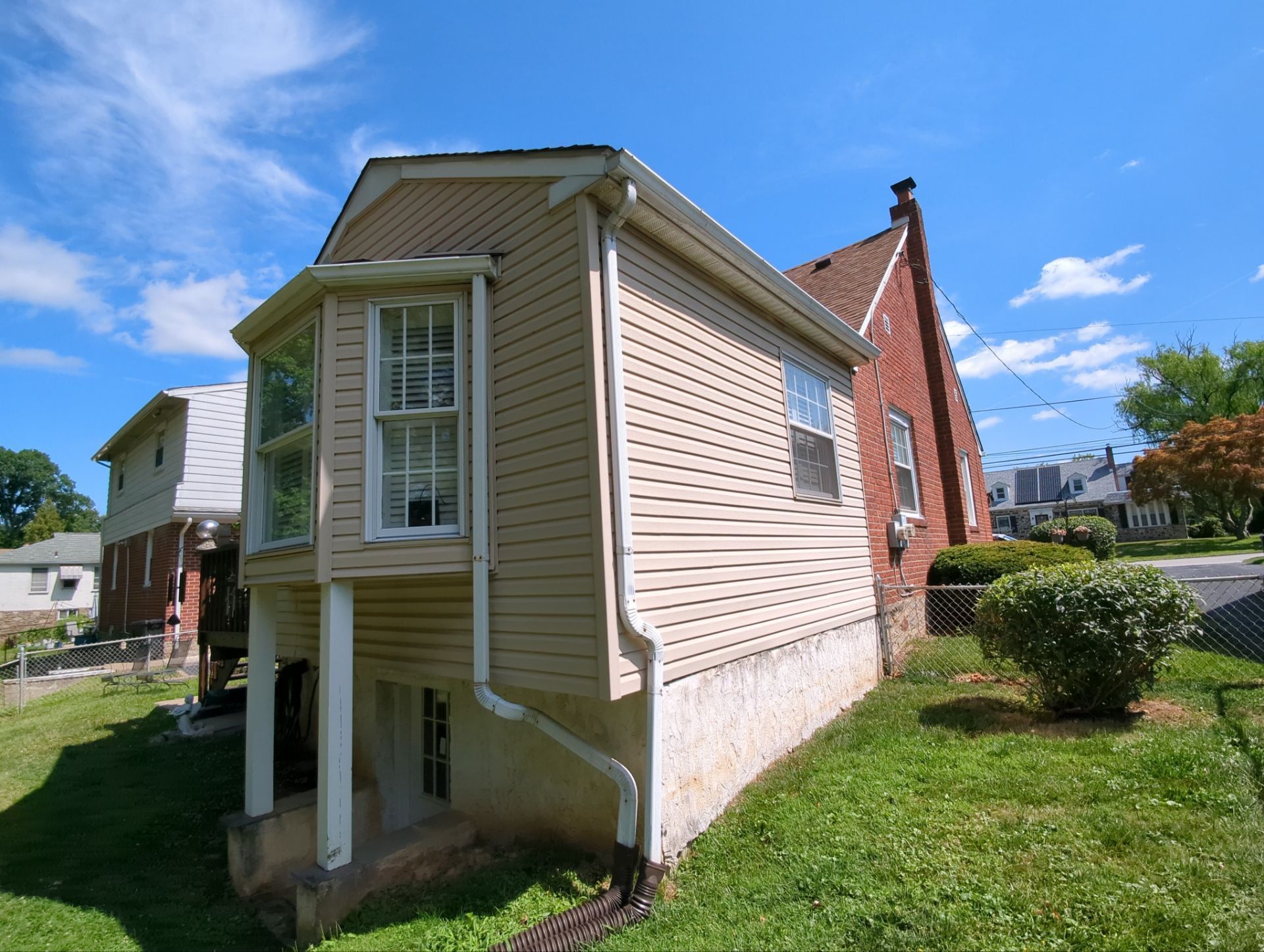 Residential home with asphalt shingle roofing, siding, chimney, and exterior drainage system on East Leamy Avenue in Springfield PA
