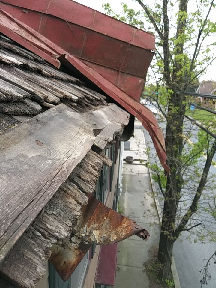 Severely deteriorated roof edge and rusted metal flashing on Heidelberg Avenue in Schaefferstown, PA showing extensive wood rot and structural damage.