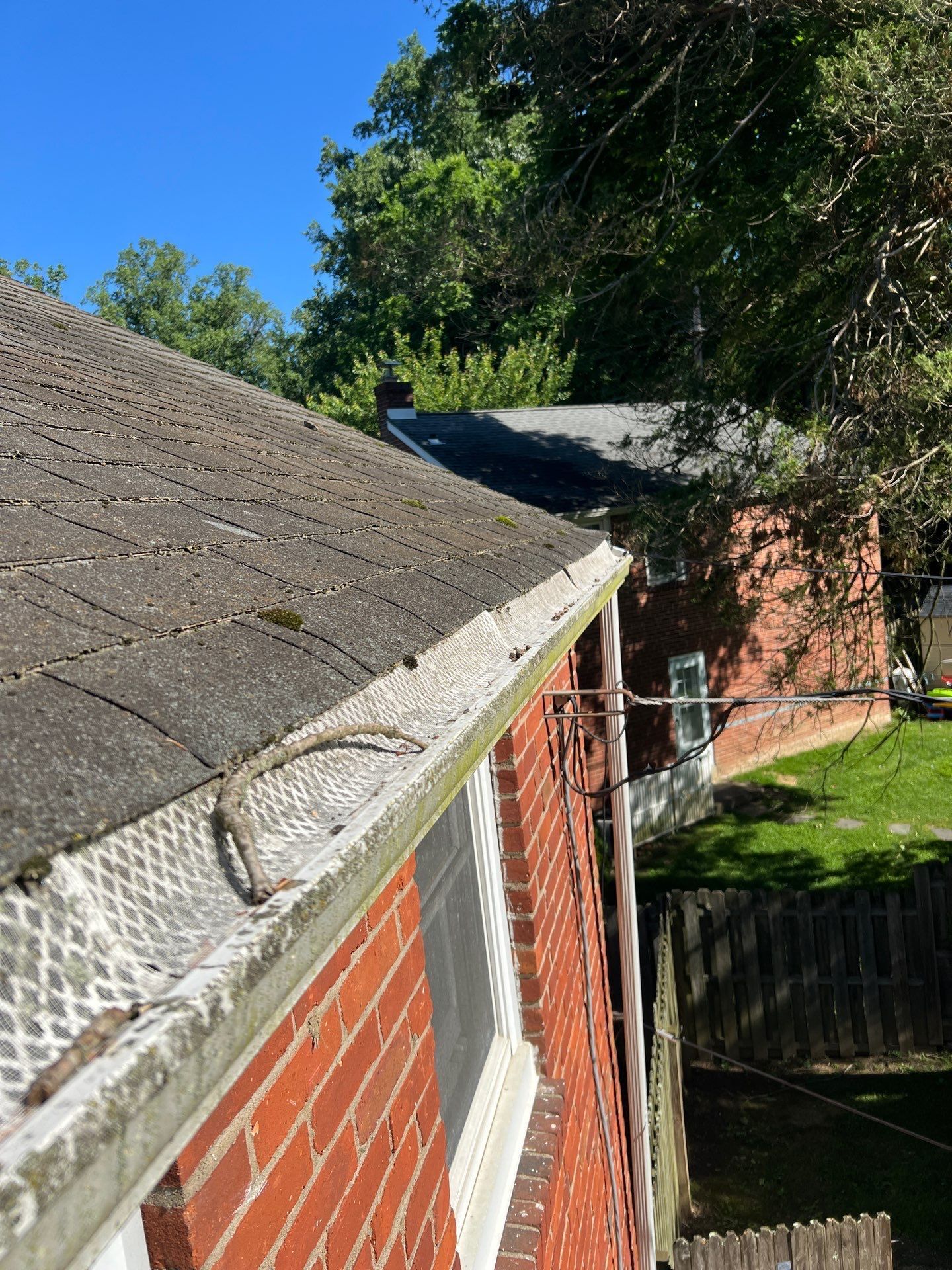 Aging asphalt shingles and debris along the roof edge and gutter on Ashwood Road in Springfield PA