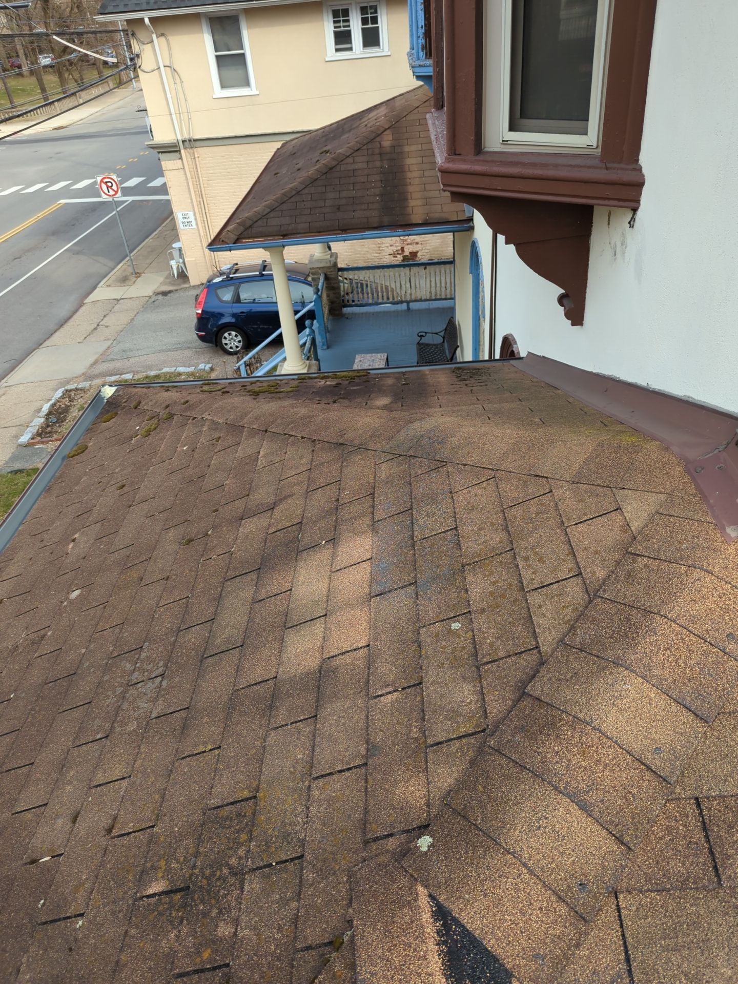 Aged asphalt shingle roof with moss growth and roof-to-wall flashing on Greenwood Avenue in Wyncote, PA