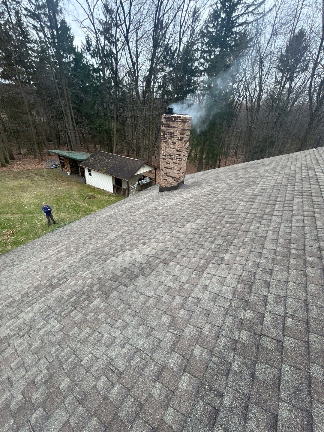 Architectural shingle roof inspected near a brick chimney on West Bethany Road.