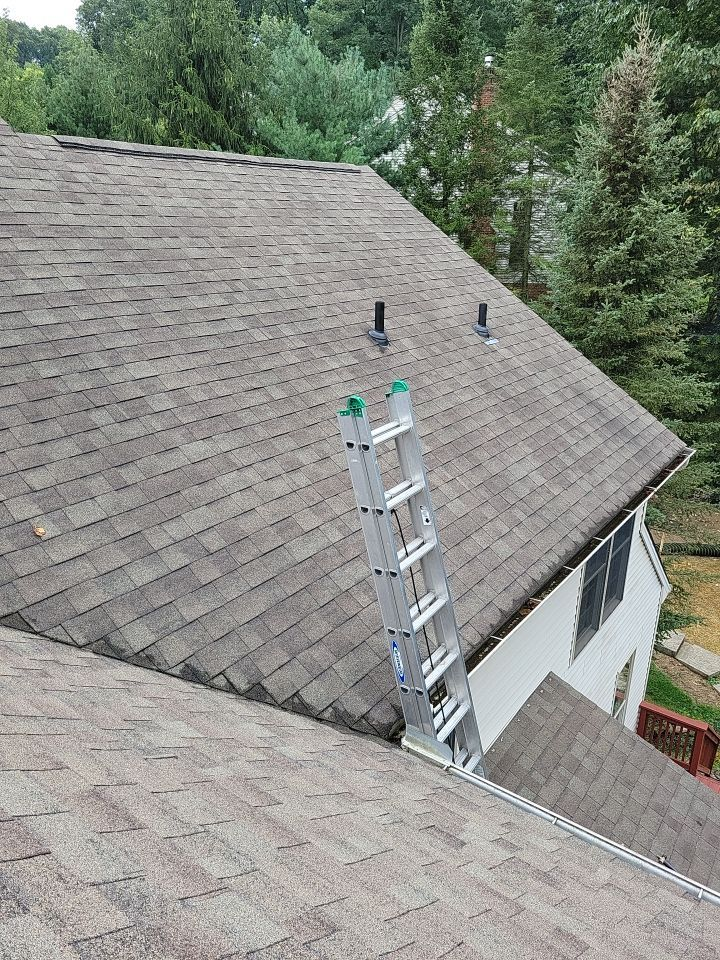 Roof repair in progress on an asphalt shingle roof with a ladder positioned for access on Deer Path Drive in Red Lion, PA.
