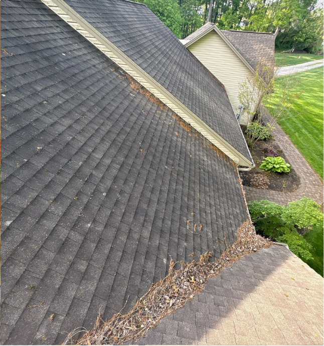 Image of an old asphalt shingle roof with a lot of debris and clogged roof valleys before it was replaced during a roof replacement project by Joyland Roofing in York, PA.
