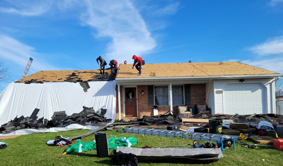 Joyland Roofing crew removing old asphalt shingles during a roof replacement on South Sheridan Road in Newmanstown, PA.