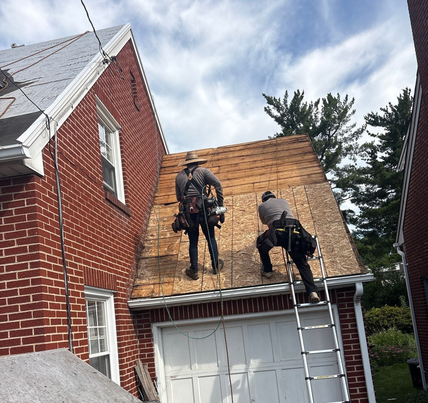 Roof replacement process on Cherry Street in Lancaster, PA showing Joyland Roofing crews installing new roof decking after removing worn asphalt shingles and damaged roofing materials.