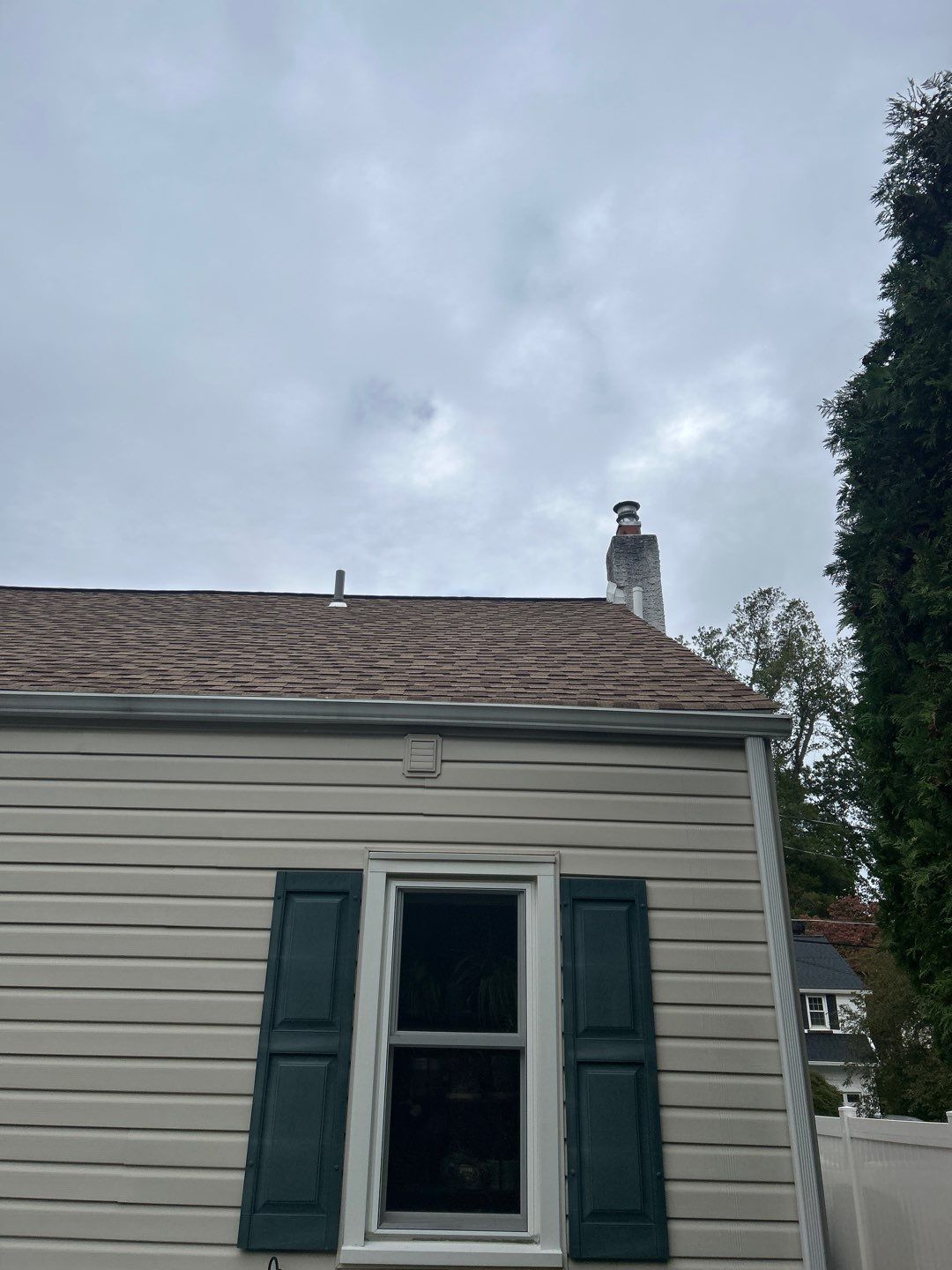 Residential shingle roof and chimney viewed from the side of a home in Wyndmoor, PA