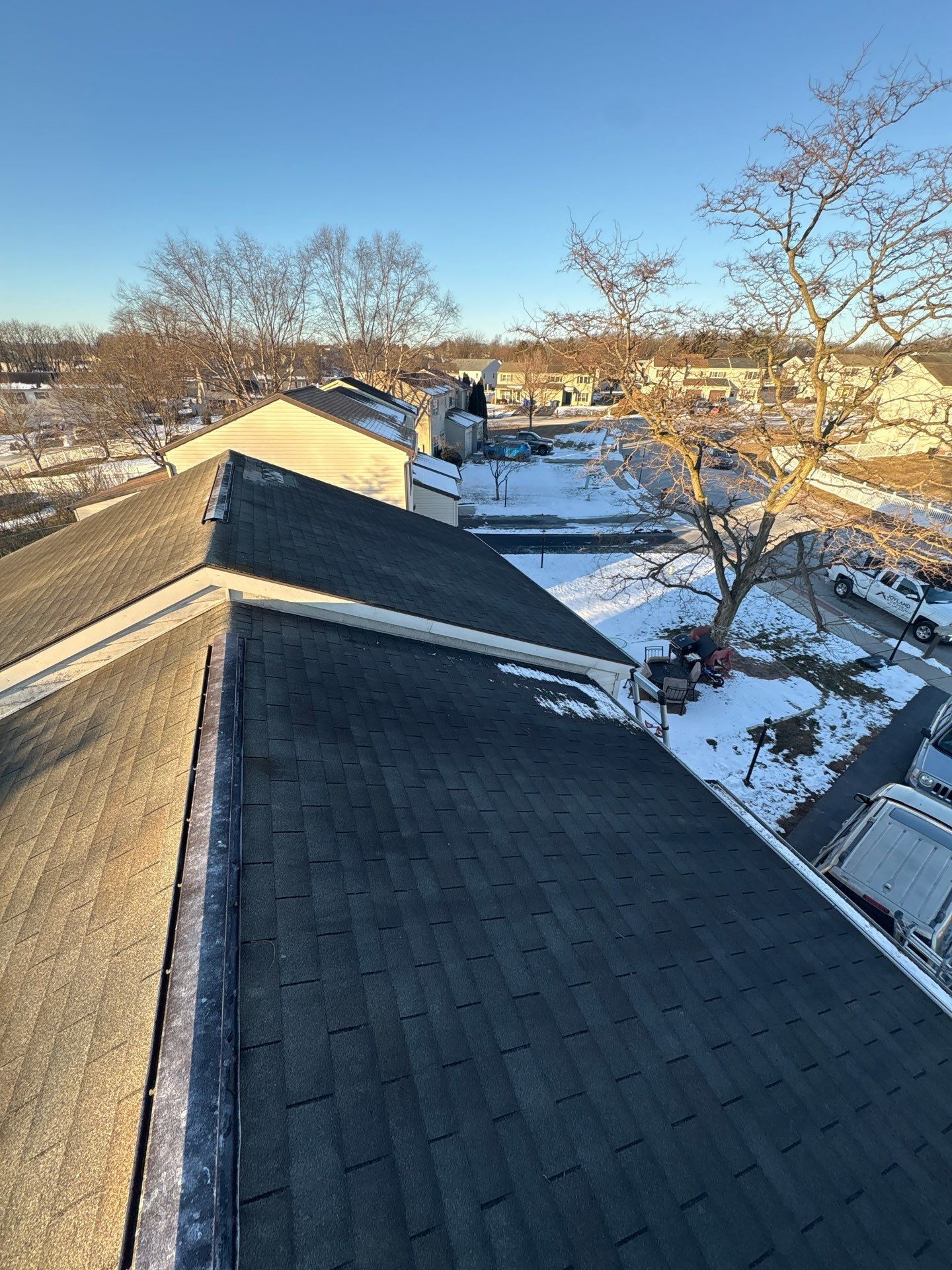 Completed asphalt shingle roof replacement on a home on Spectrum Road in Dover, PA during winter with light snow surrounding the property.