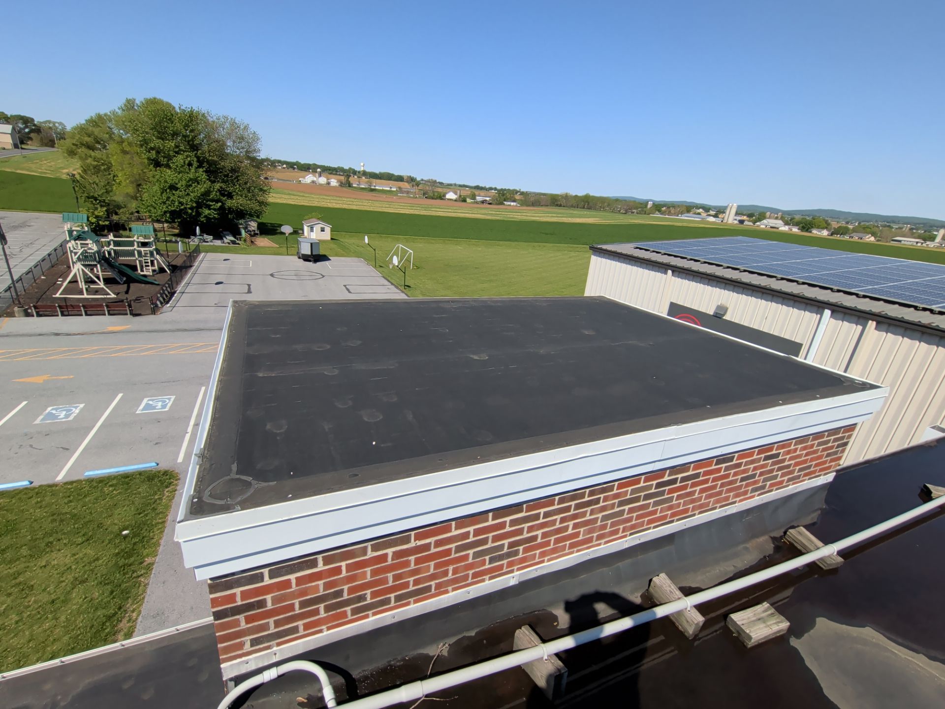 Completed roof replacement on Stevens Road in Ephrata, PA featuring a professionally installed low-slope roofing system with custom metal edge details.
