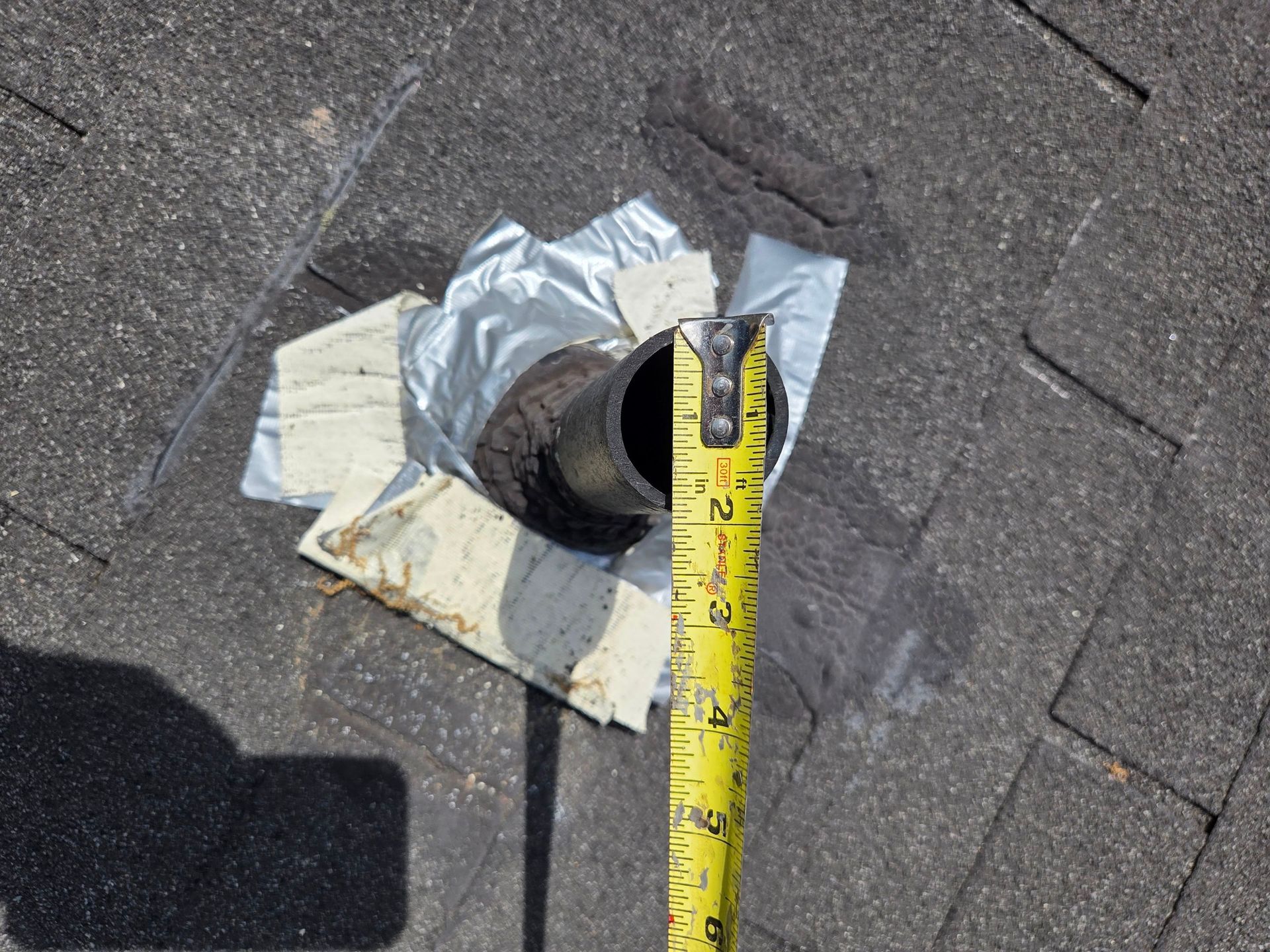 Damaged roof vent flashing being measured during a roof replacement project on Watercress Lane in Elizabethtown, PA to ensure proper ventilation and leak protection.
