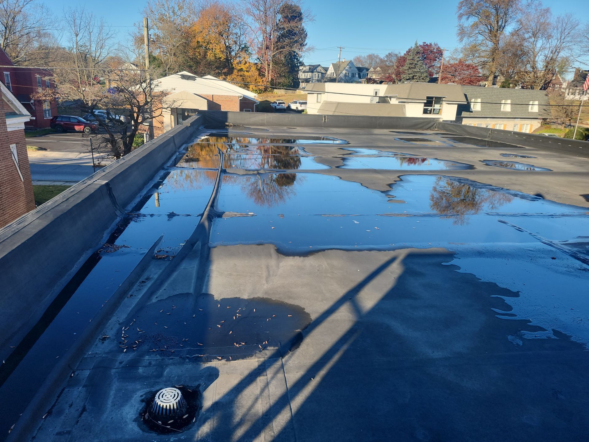 Standing water covering sections of a commercial flat membrane roof with roof drains visible during a roof inspection in Quarryville, PA.