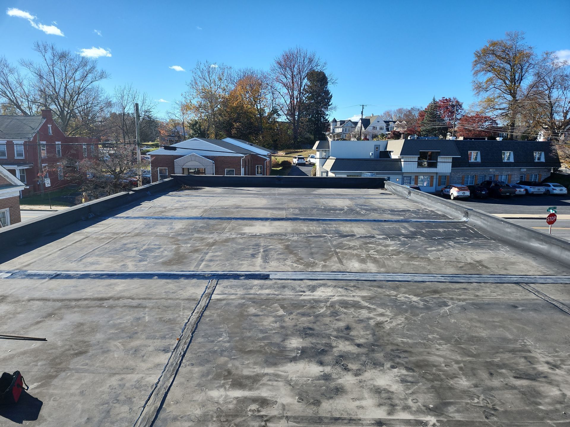 Commercial flat membrane roof on Scottland Road in Quarryville, PA showing weathered roofing material and reinforced seams during a roof restoration inspection.