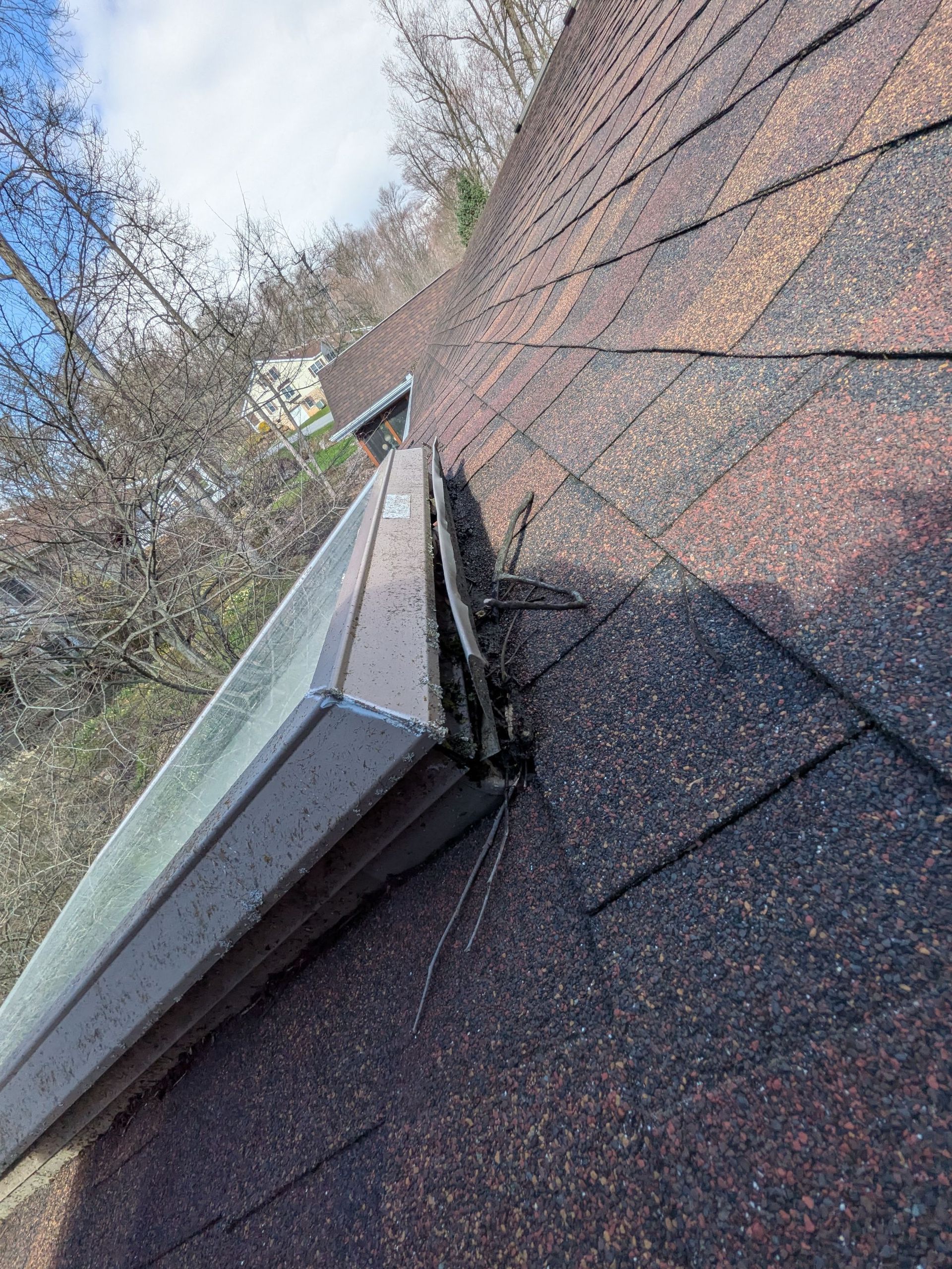 Skylight leak repair inspection at Timber Villa in Elizabethtown, PA showing damaged flashing and debris buildup around a roof-mounted skylight on an asphalt shingle roof.