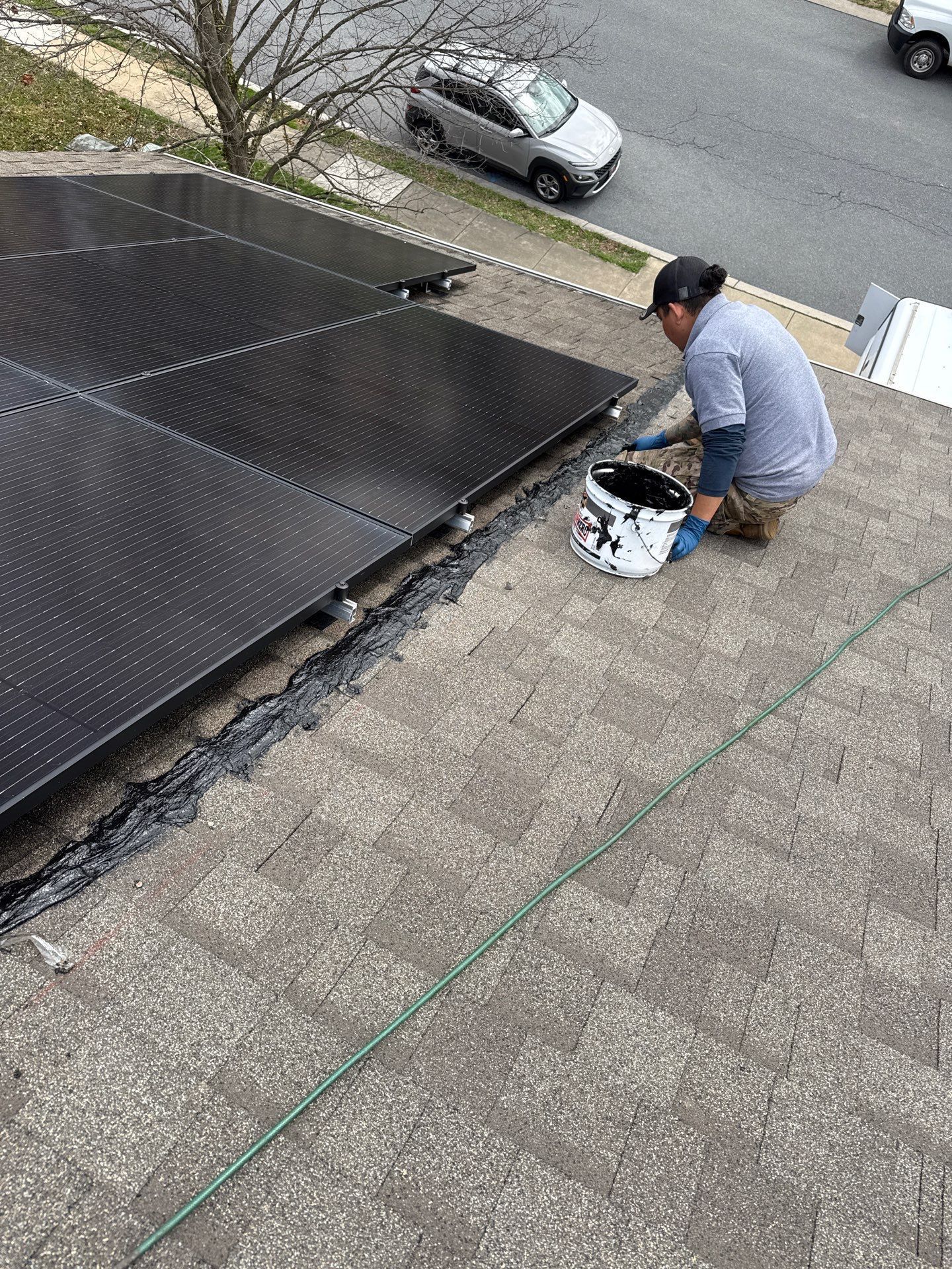 Roof repair being completed around solar panel mounting areas on an asphalt shingle roof on Eagle Drive.
