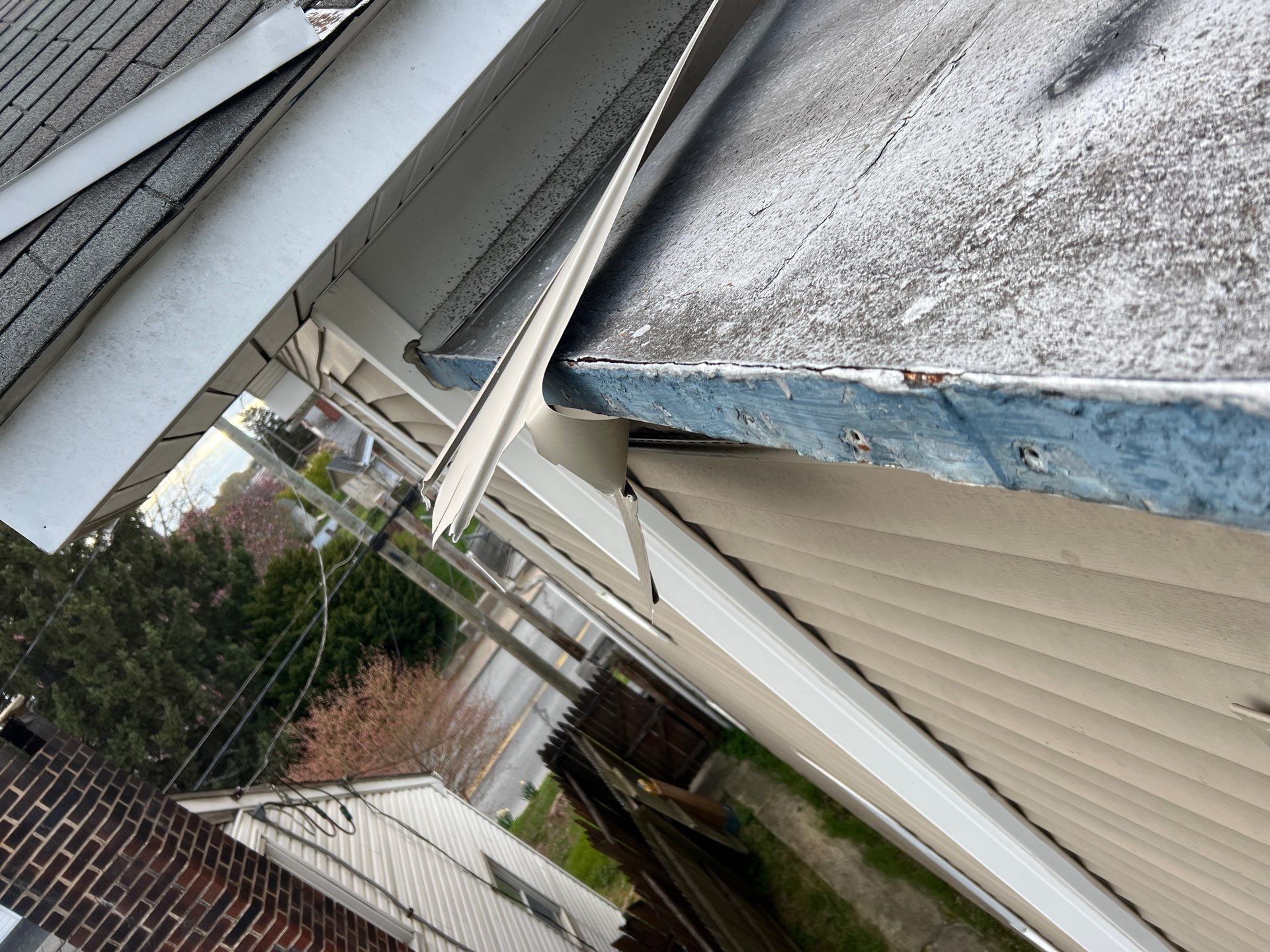 Damaged aluminum gutter pulling away from the roof edge with deteriorated fascia trim and asphalt shingles on a residential home in Quarryville, PA.