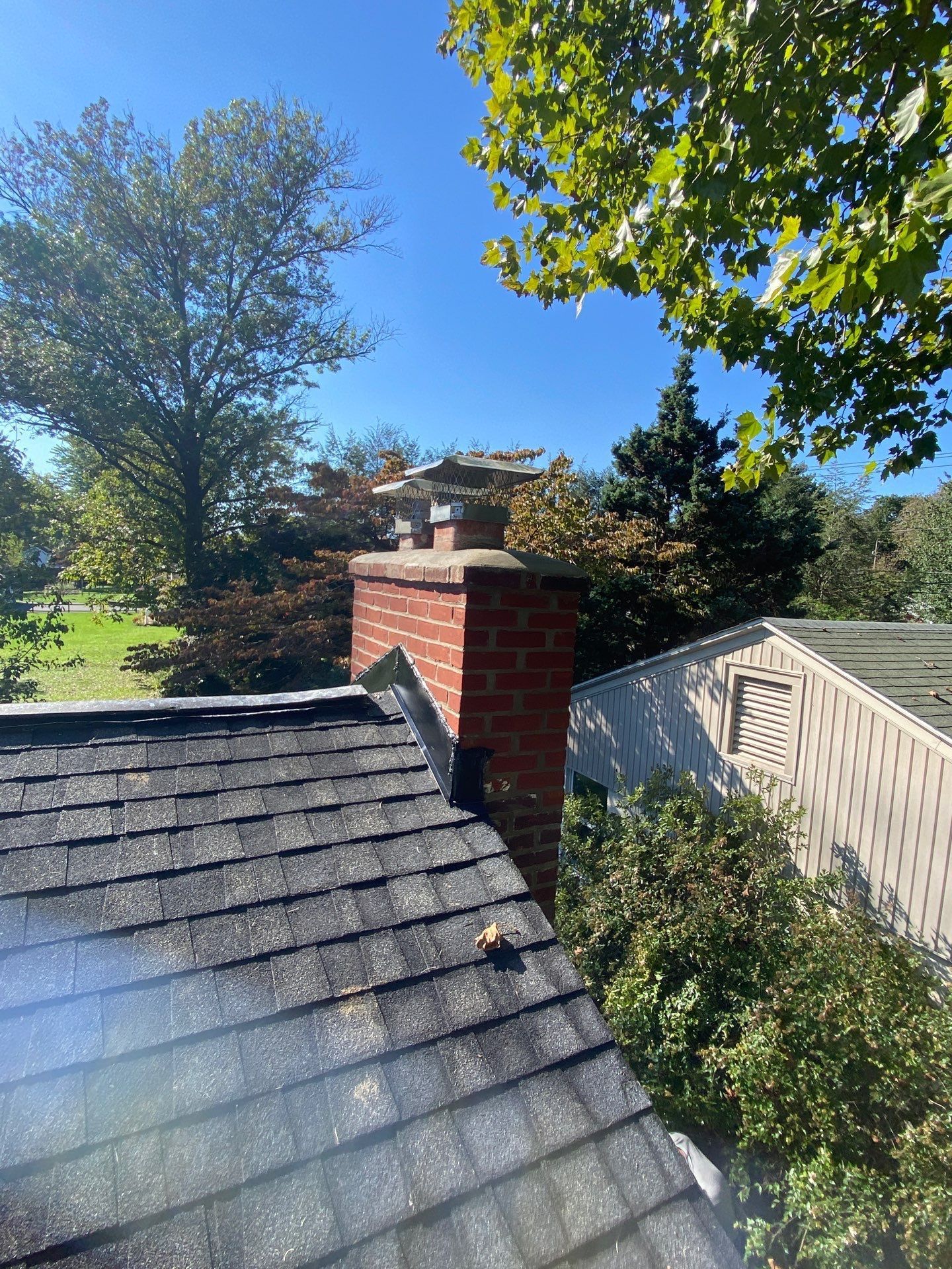 New chimney flashing repair completed on an asphalt shingle roof on South Stoner Avenue in Shiremanstown, PA.