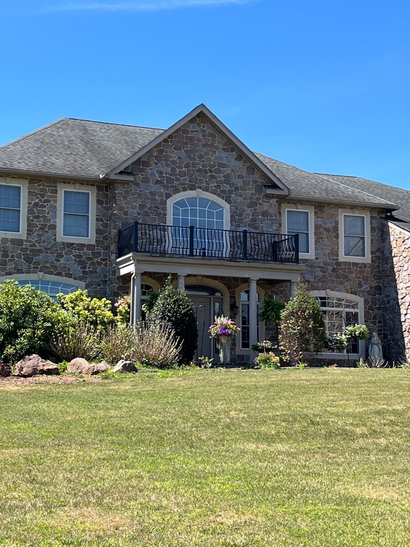 Asphalt shingle roof on a stone-front home along Spruce Drive