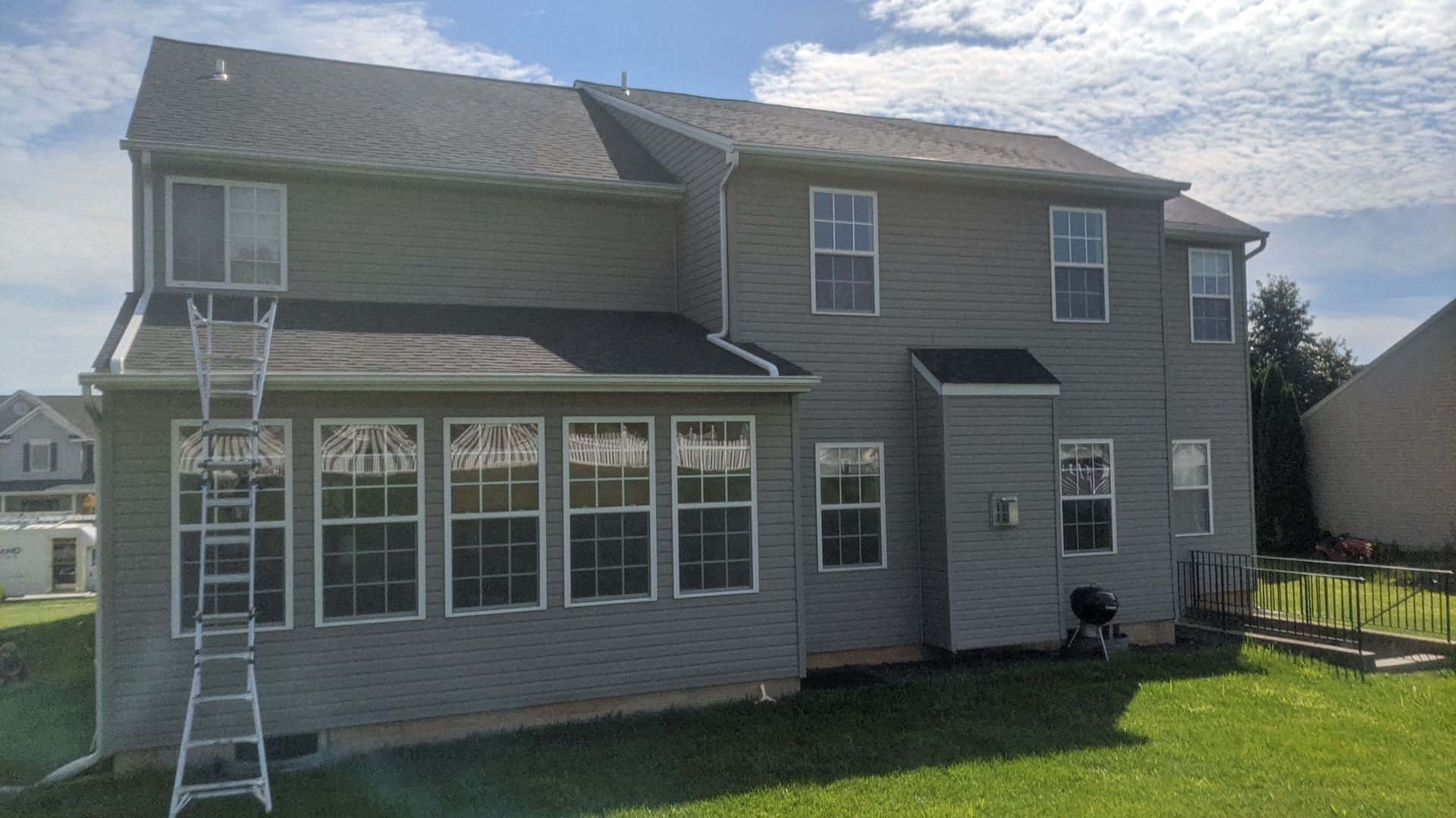 Rear exterior view of a two-story home in York, PA featuring a completed asphalt shingle roof installation by Joyland Roofing.