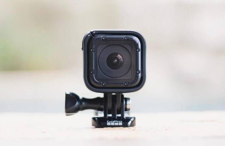 GoPro camera, black, mounted on a black base, close-up, outdoors.