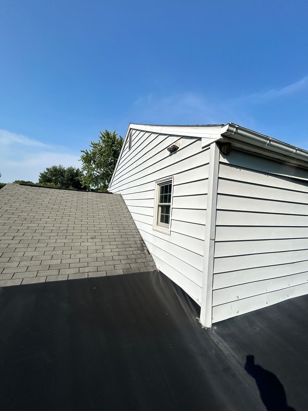 New flat roofing membrane and asphalt shingle roof replacement completed on West Norman Street by Joyland Roofing.