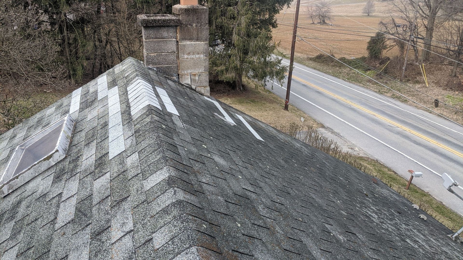 Aging asphalt shingle roof with visible repair patches inspected by Joyland Roofing on West Trindle Road.
