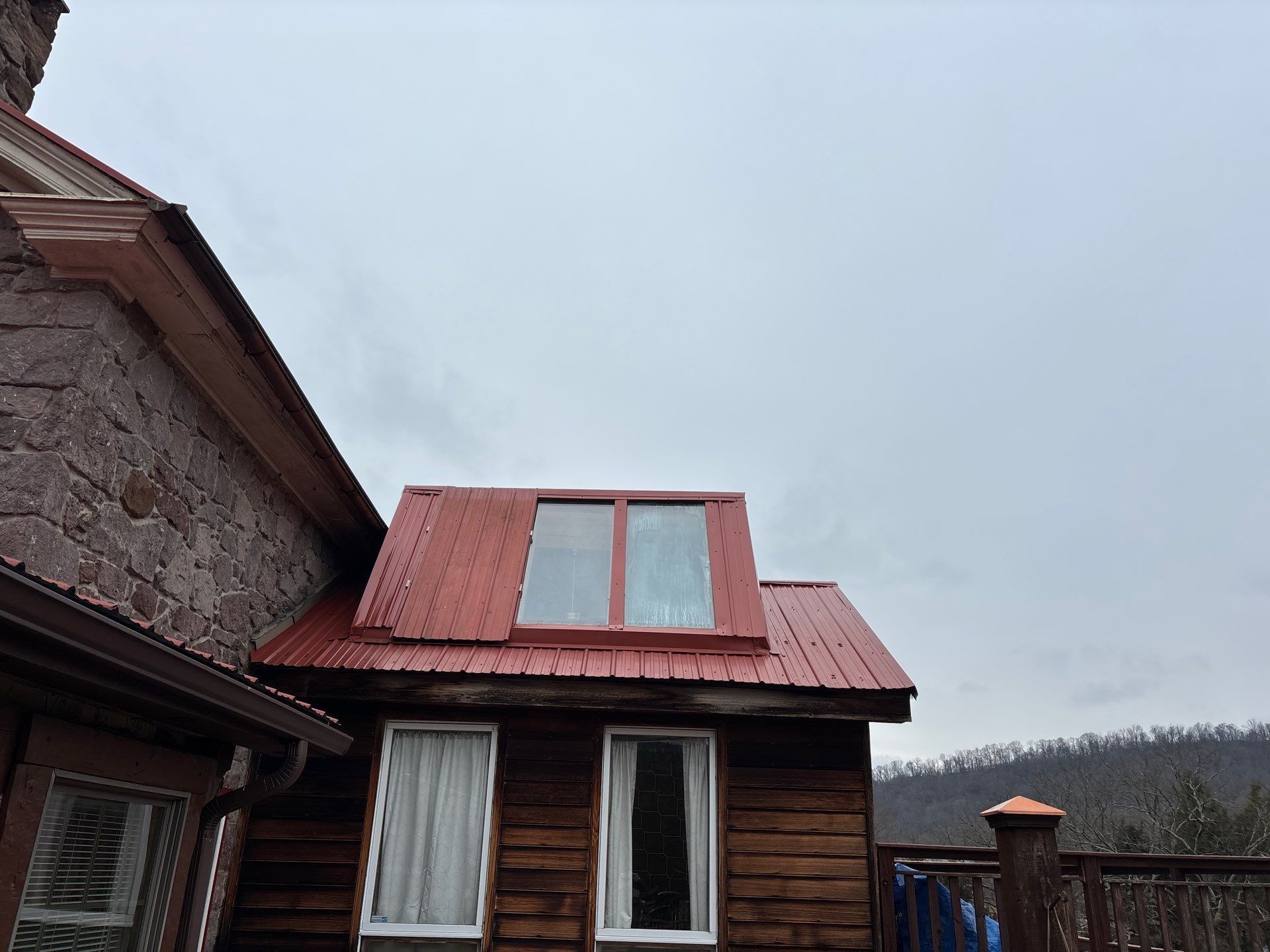 Red standing seam metal roof with skylight on a Whitebear Road home
