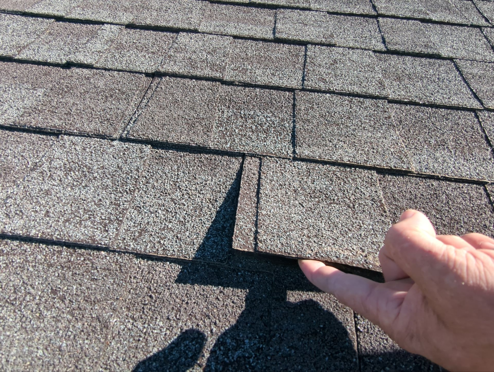 Image of an old asphalt shingle roof with a lot of debris and clogged roof valleys before it was replaced during a roof replacement project by Joyland Roofing in York, PA.