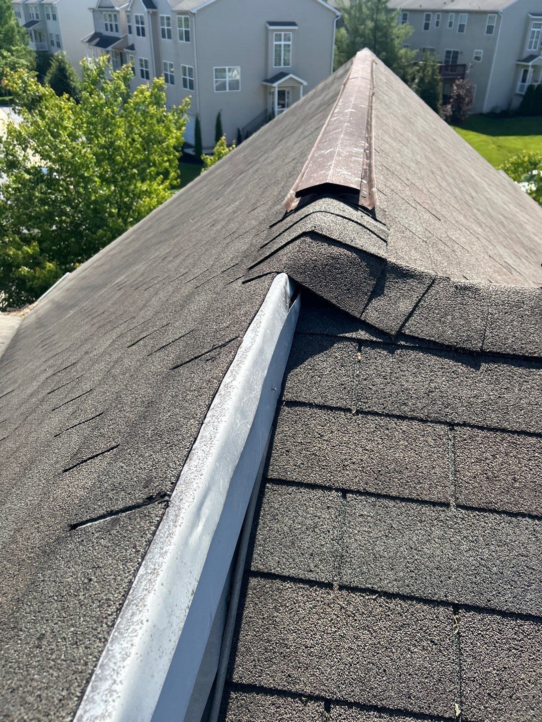 Roof replacement on Woodside Court by Joyland Roofing showing new architectural shingles and ridge vent installation.