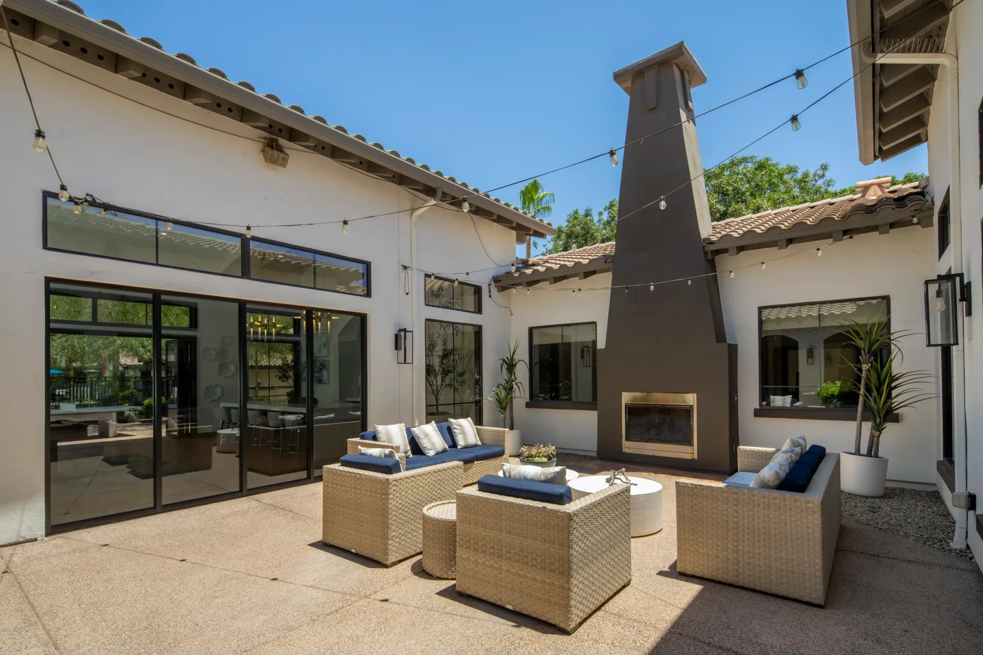 Outdoor patio with wicker furniture and a fireplace.