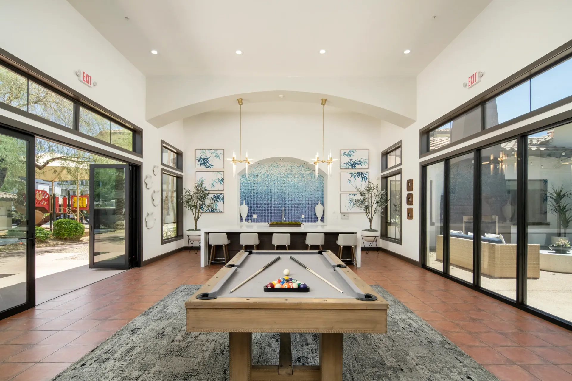 Billiards room with a pool table and bar seating.