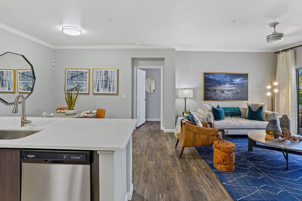 Open-concept apartment living area with kitchen island, dining nook, and a seating area.