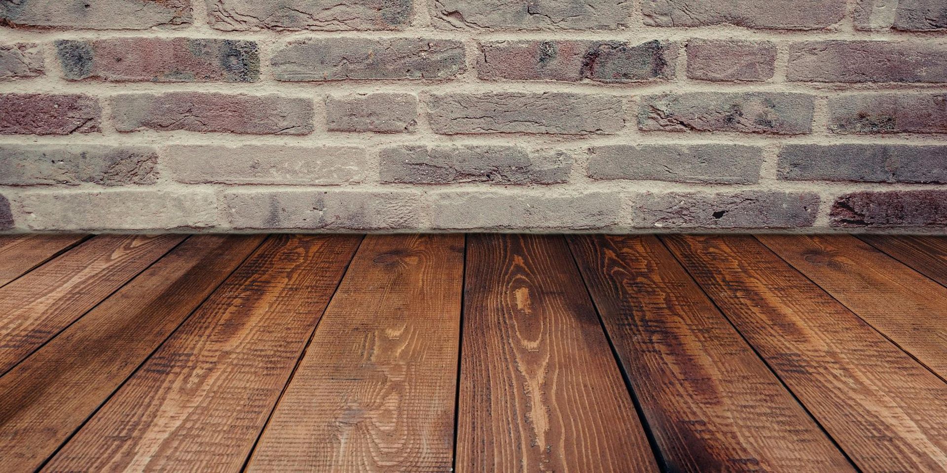 Wooden floor against a brick wall.