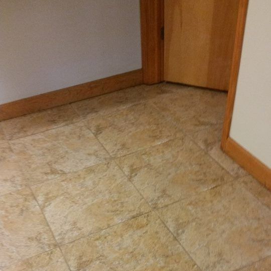 A tiled floor in a hallway next to a door A tiled floor in a hallway next to a door
