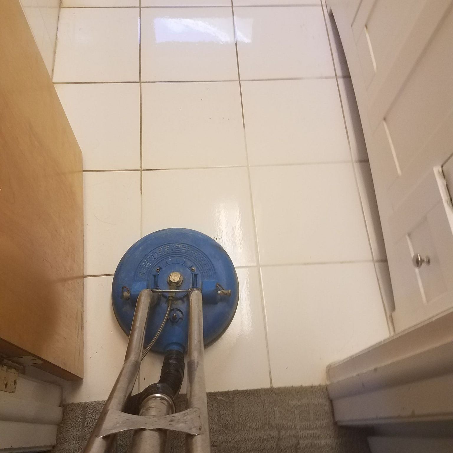 A blue machine is sitting on a tiled floor in a room. A blue machine is sitting on a tiled floor in a room.