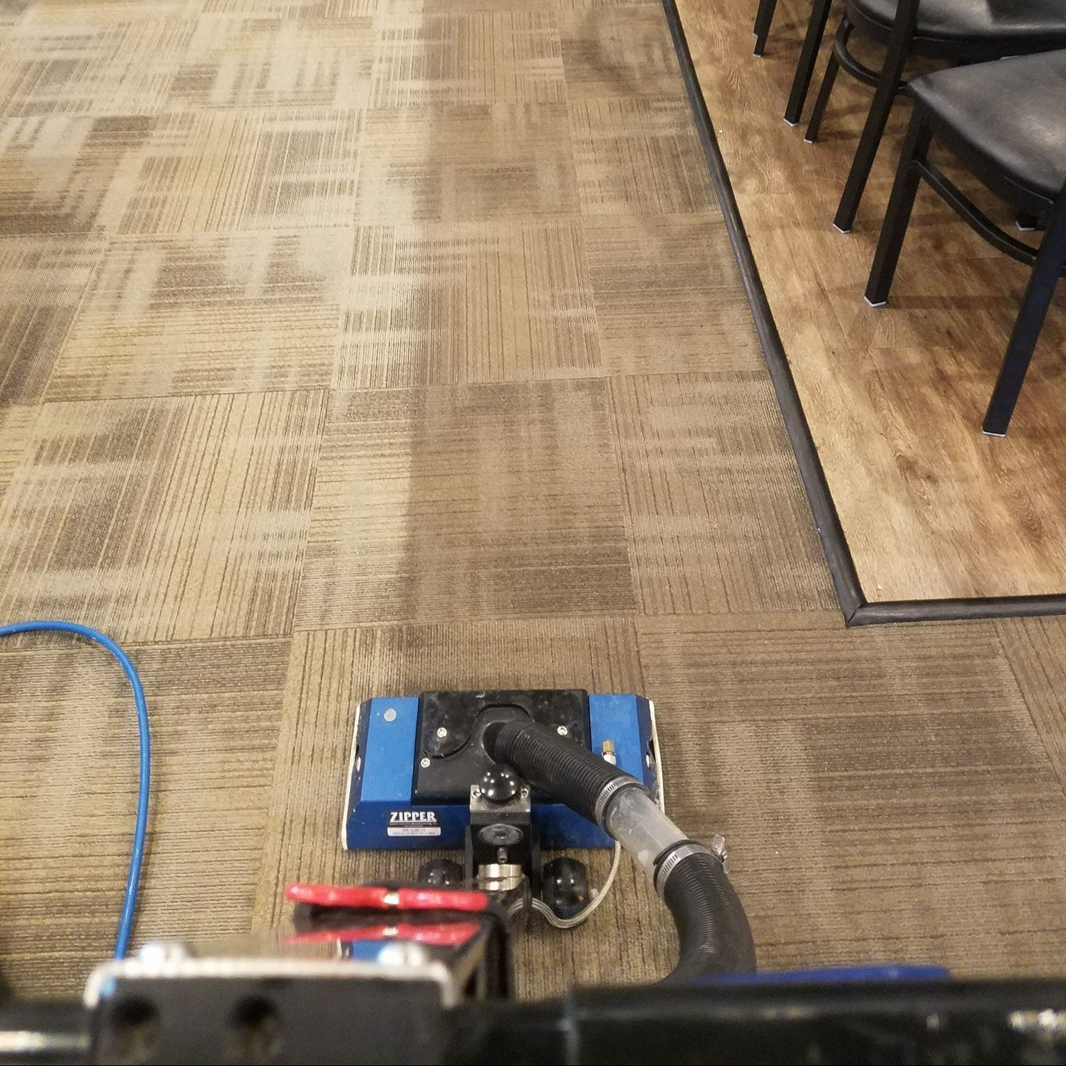 A vacuum cleaner is cleaning a carpet in a room. A vacuum cleaner is cleaning a carpet in a room.