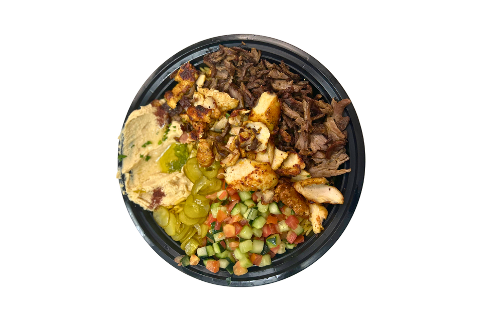 A black bowl filled with a variety of food on a white background.
