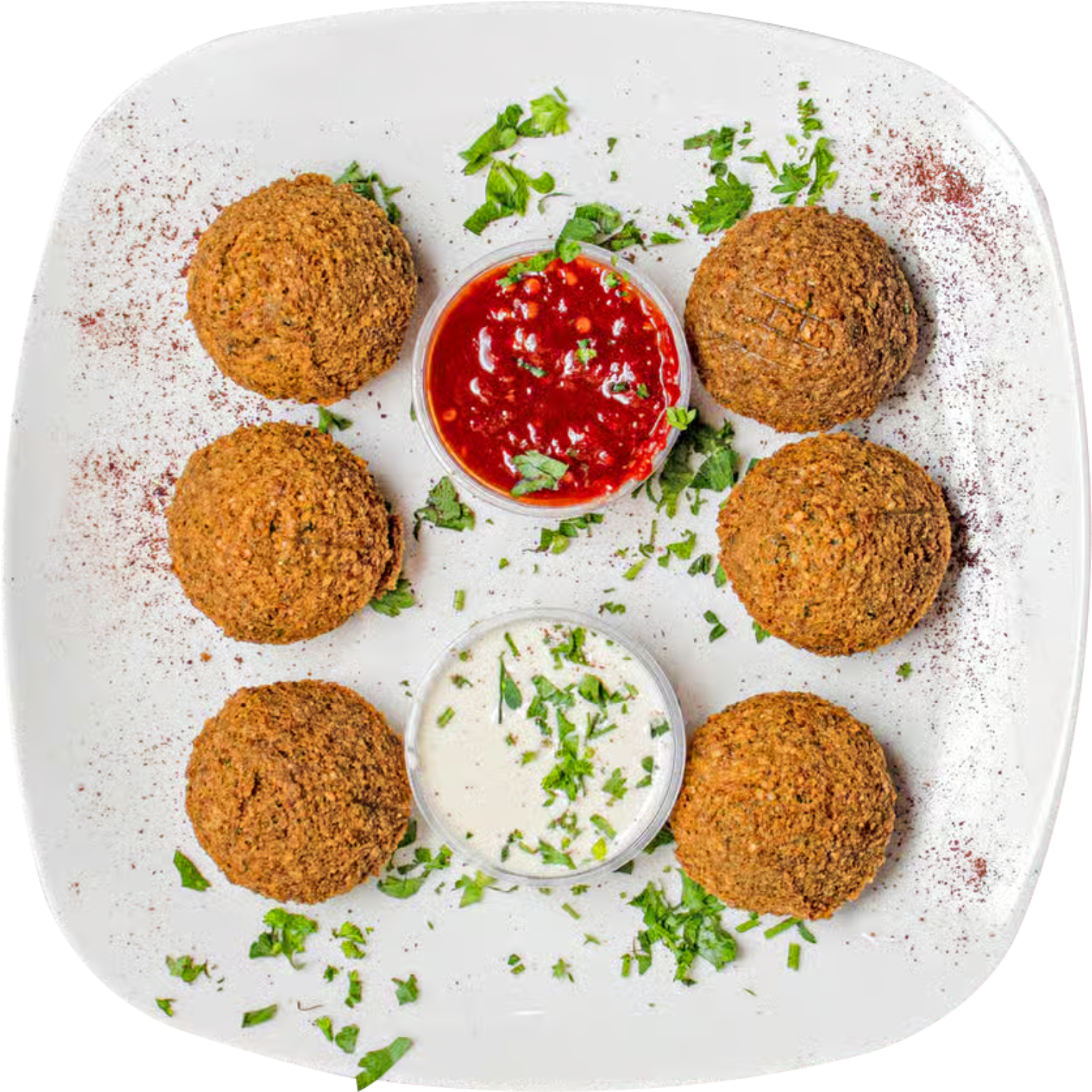 A white plate topped with falafel balls and sauce.