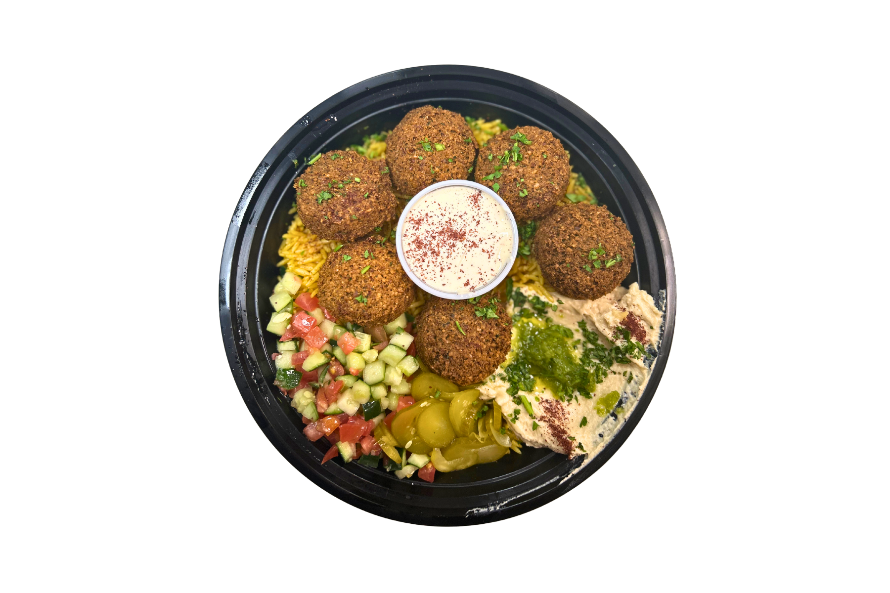 A bowl of food with falafel , hummus , rice and vegetables on a white background.