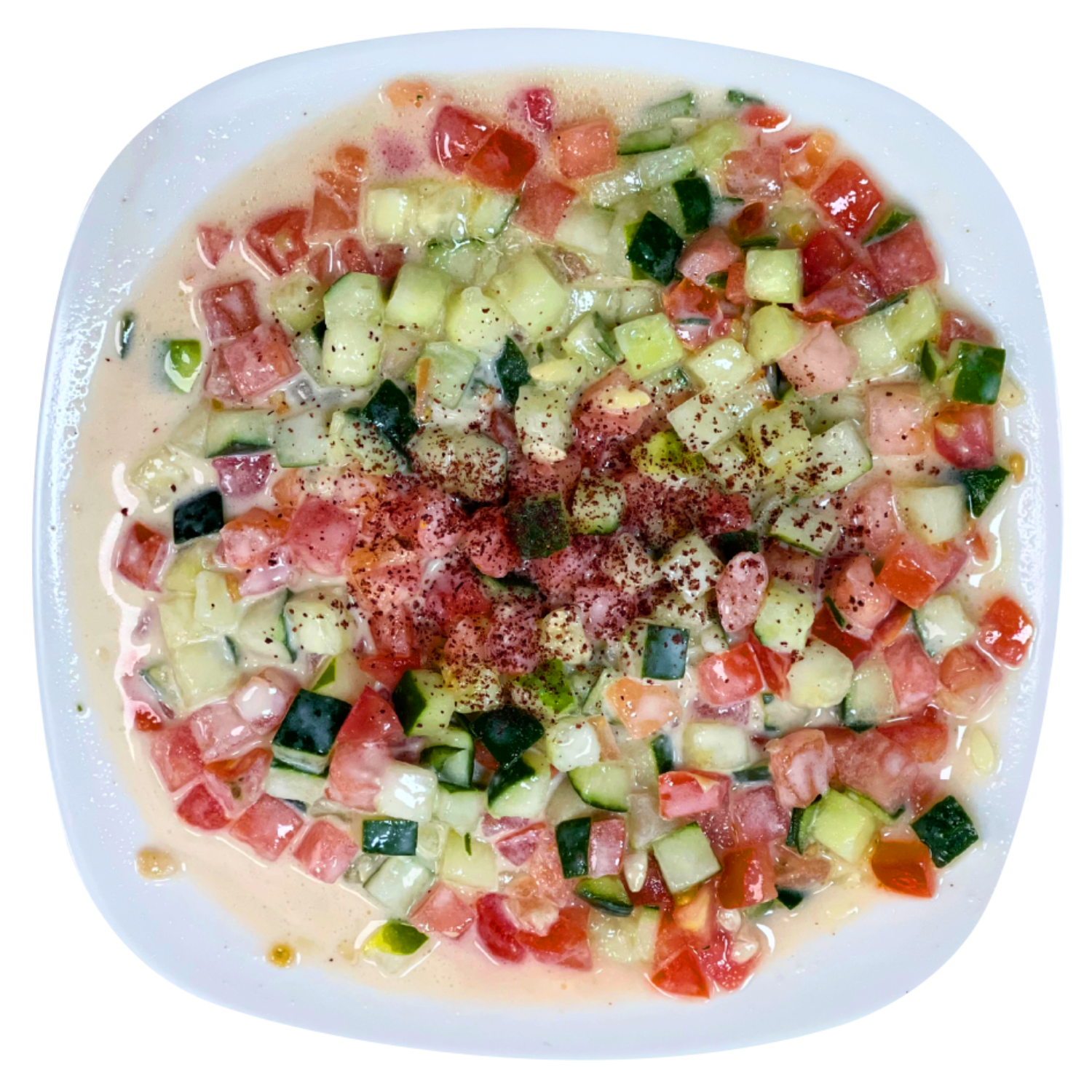A white plate topped with a salad of tomatoes and cucumbers