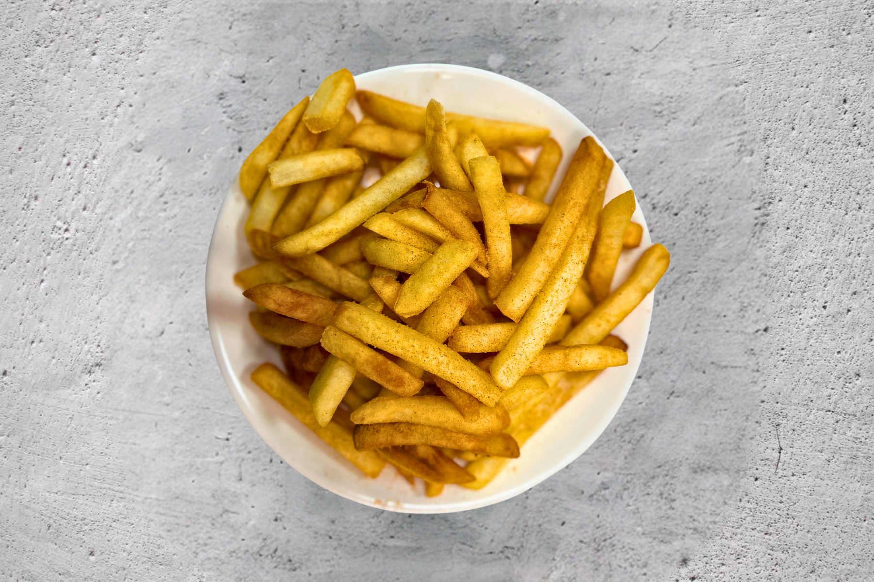 A white plate topped with french fries on a table.