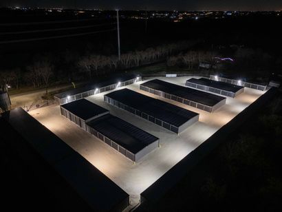 Night aerial view of The Reserve Self Storage in Gunter, TX highlighting fully fenced property and security lighting