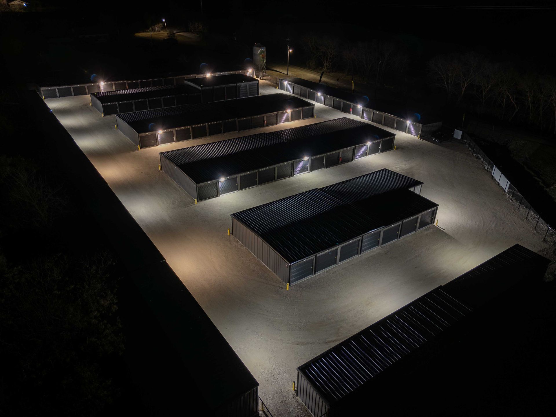 Night aerial view of The Reserve Self Storage in Gunter, TX showing well-lit drive-up storage units and secure layout