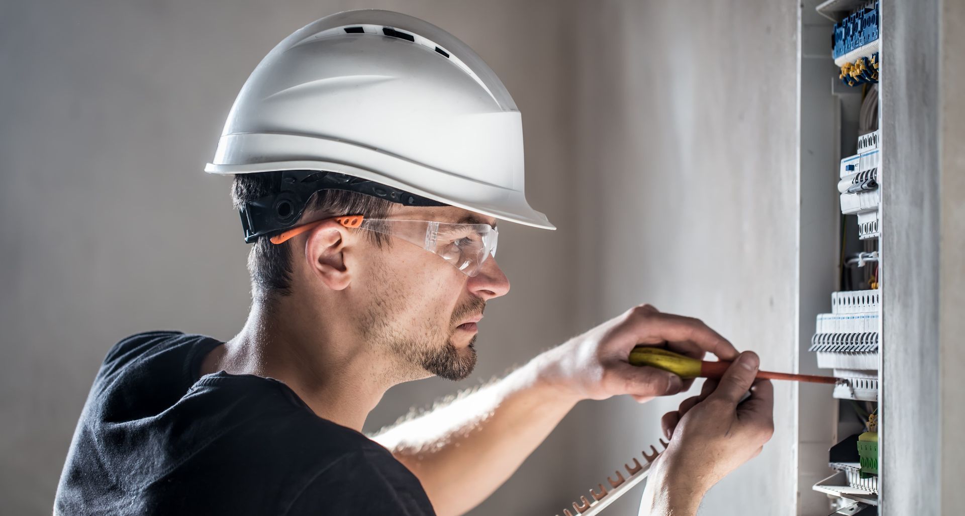 Electrical Technician Working In A Switchboard With Fuses