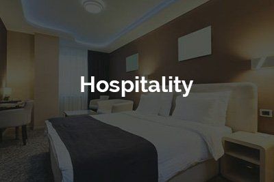 A hotel room with a bed and the word hospitality written on it.