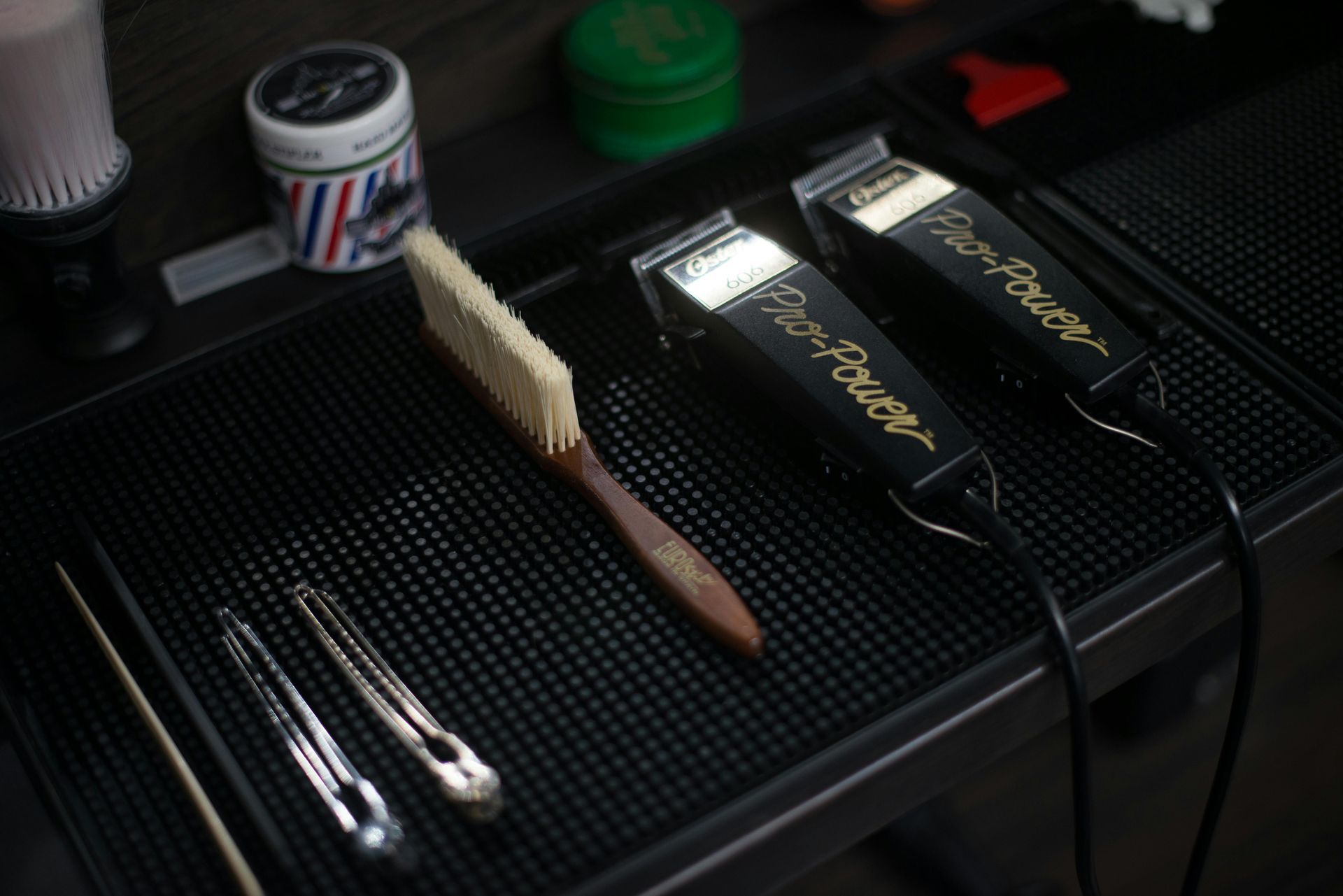 Two wahl hair clippers and a brush on a mat
