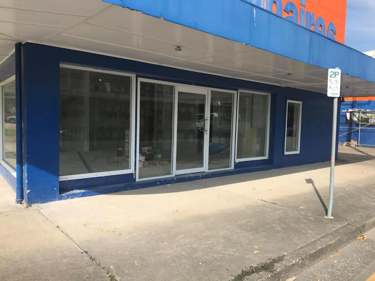 A Blue Building With A No Parking Sign In Front Of It — Datco Windows & Doors Pty Ltd In South Murwillumbah, NSW