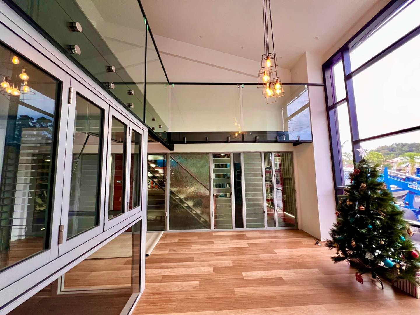 Spacious Modern Interior With Large Windows, Wood Floors, and Glass Railings — Datco Windows & Doors Pty Ltd In South Murwillumbah, NSW
